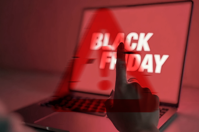 Imagem de um notebook sobre uma mesa com o texto black friday escrito na tela e imagem de uma mão apontando para a tela